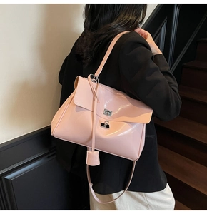 Detail of pink patent leather tote bag featuring a silver twist lock and glossy finish