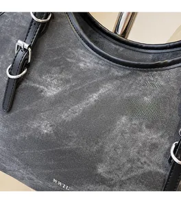 Vue détaillée en gros plan du tissu en denim gris délavé avec texte blanc WWTU et couture