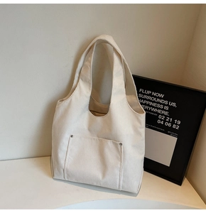 Close-up of beige corduroy tote bag featuring thick ribbed fabric and rivet detail