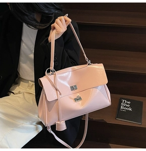 Detail of pink patent leather tote bag showing silver square twist lock and glossy finish