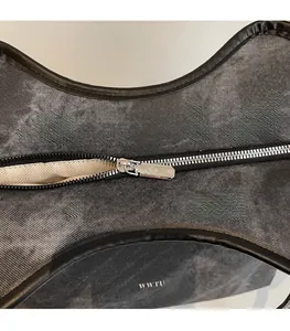 Détail du sac en denim gris avec fermeture éclair argentée et logo WWTU blanc