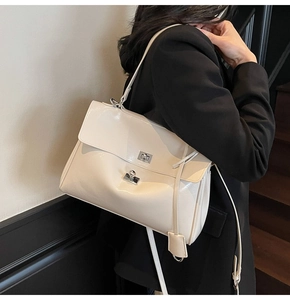 Detail of cream glossy leather tote bag with silver twist lock and polished finish
