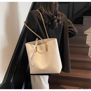 Detail of cream tote bag with silk scarf accessory and Fashion Trend embossing