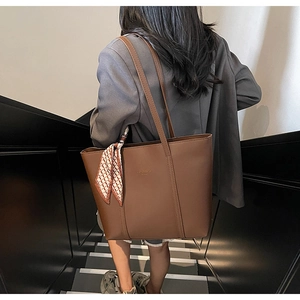 Deep brown large tote bag with silk scarf detail shown in an urban fashion setting