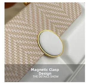 Macro view of woven texture material and oval magnetic closure with golden metal trim