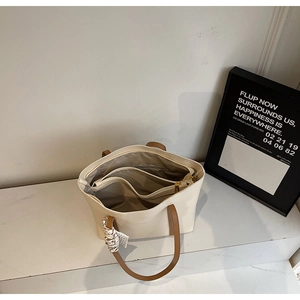 Internal view of the tote bag showing multi-compartment design and a zipped pocket