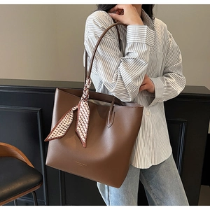Detail of coffee brown PU leather tote bag with decorative silk scarf and gold lettering