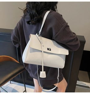 Detailed back view of a white tote bag with dual straps and silver twist lock closure