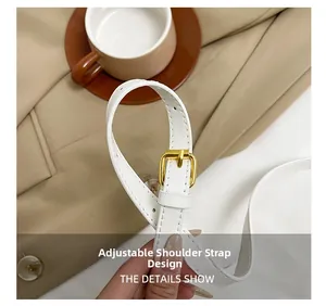 Detail of adjustable white leather shoulder strap with elegant gold metal buckle hardware