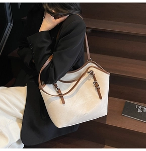 Détail du grand sac cabas en daim crème avec anses réglables marron sur escalier rétro