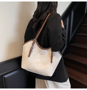 Détail de la bandoulière marron réglable et boucle sur le sac fourre-tout crème