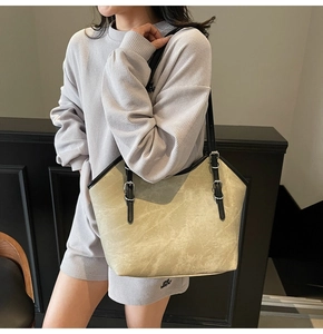 Détail du sac cabas beige à motif marbre, lanières noires contrastées et boucle argent