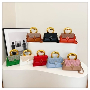 Detailed view of color-block box bags with unique gold metal handles in multiple colors