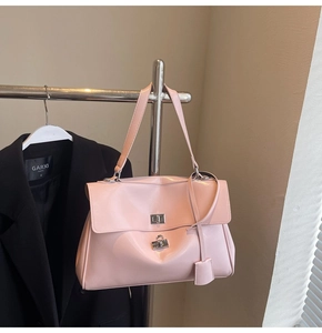 Detail of pink patent leather tote with silver metal twist lock and hanging charms