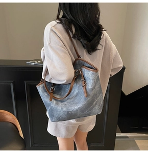 Détail du grand sac cabas bleu avec texture rétro et bandoulière en cuir marron et boucle