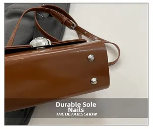 Macro view of brown glossy leather bag bottom with silver metal protective studs
