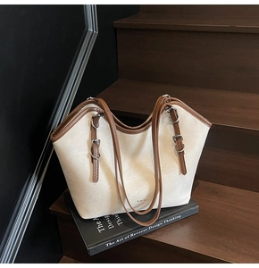 Détail de la bandoulière réglable en cuir marron avec boucle en métal argenté sur un sac fourre-tout