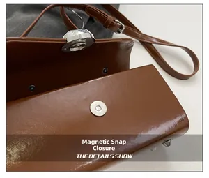 Macro shot of brown box bag showing secure magnetic snap closure and silver hardware details
