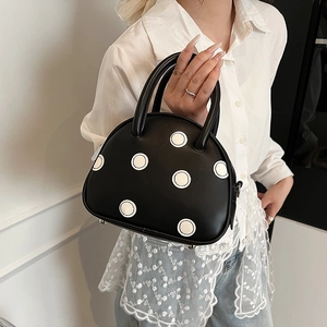 Sac à main noir à pois avec double poignées et détails de quincaillerie métallique argentée