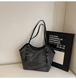 Gros plan du sac cabas gris texture marbre avec logo WWTU et bandoulières noires