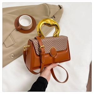 Retro houndstooth box bag with golden curved handle on a warm lifestyle background