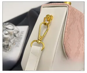 Detail of premium gold-tone metal hook and pink snake-pattern leather on women's bag