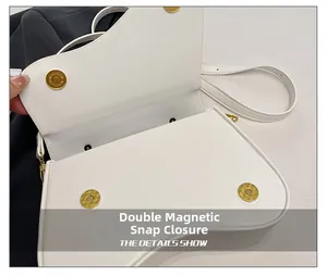 Detail view of the white saddle bag featuring secure double gold magnetic snap closures