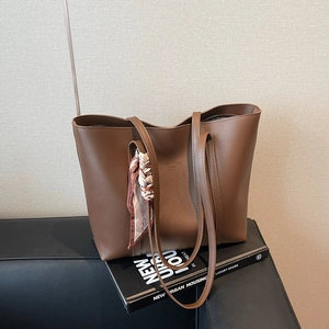 Brown textured large tote bag with scarf detail for women on a stylish setting