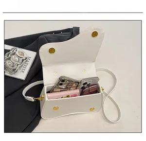 Interior capacity detail showing a white leather saddle bag holding two phones and a wallet