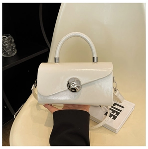Detail of white mini square bag with silver spherical lock and shiny faux leather texture