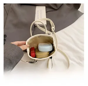 Internal view of cream mini bag showing capacity for lipstick and small tech accessories
