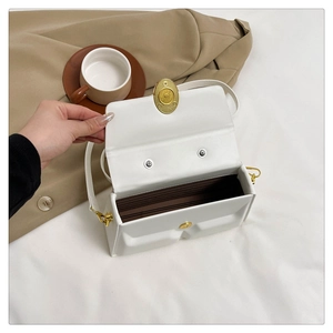 Detail of white PU leather crossbody bag showing multi-layer inner compartments and gold buckle