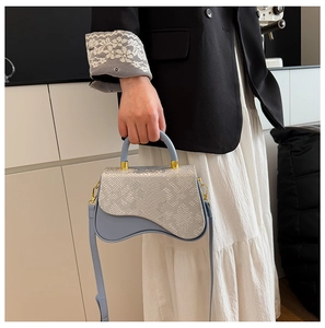 Detail of blue and silver asymmetric box bag showing snakeskin texture and strap