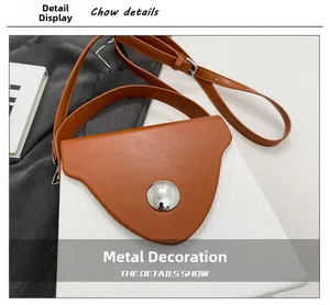 Detail of contrast stitch handbag with oversized silver sphere buckle and brown leather