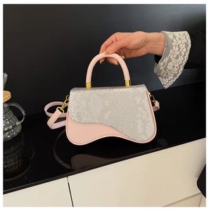 Close-up of pink and silver snake print handbag with golden hardware and handle