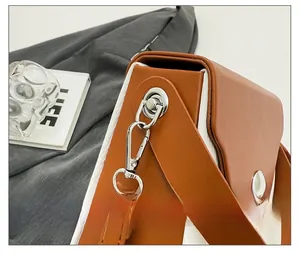 Detail of silver metal hook and premium stitching on two-tone brown and white bag