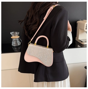 Chic pink box bag with snake pattern flap and unique wavy base on a model in a cafe setting