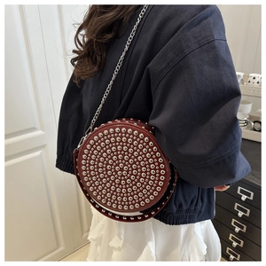 Detail of burgundy round rivet shoulder bag with silver studs and chain strap