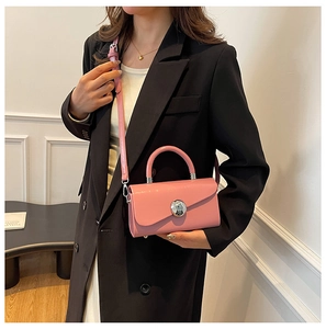 Detail of pink matte leather box bag with silver metal buckle and crossbody strap