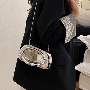 Detail of silver metallic crossbody bag with futuristic wave shape and chain strap