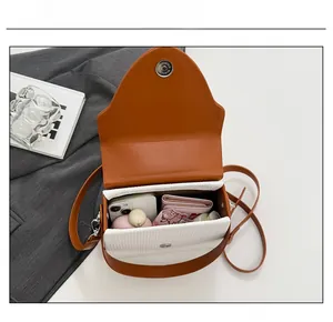 Top view showing internal capacity of the two-tone crossbody bag with daily essentials