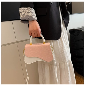 Detail of a wave-shaped contrast box bag featuring pink snakeskin texture and white leather
