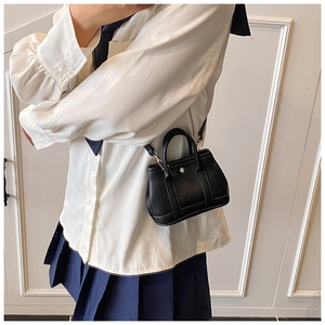 Detailed macro view of black lychee grain mini handbag with silver hardware and strap