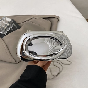 Detail of silver metallic mirror clutch with streamlined shape and detachable chain strap