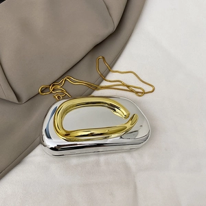 Detailed close-up of a silver mirror finish evening clutch with gold metallic accents