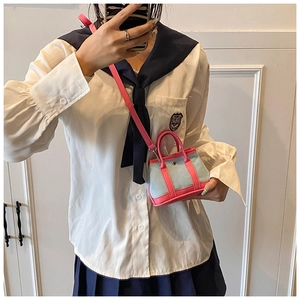 Mirror selfie showing the mini light blue denim tote with rose pink leather trim and strap