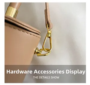Detail of premium gold hardware hooks and D-rings on a beige leather crossbody bag
