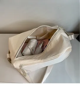 Top view of cream nylon shoulder bag showing spacious interior with daily essentials