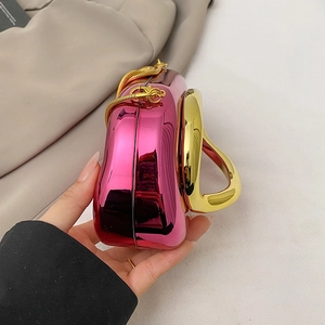 Detail of metallic rose pink clutch bag with a unique gold handle and detachable chain