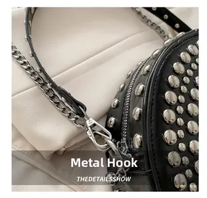 Close-up of durable silver hardware hook and rivet details on black leather shoulder bag